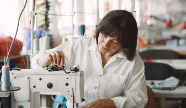 algo-elegant-old-woman-sitting-in-studio-and-sew-cloth